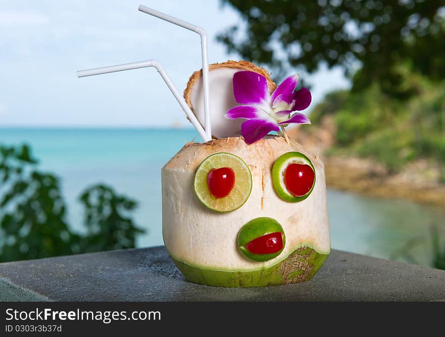 Exotic coconut cocktail against blue water and sky