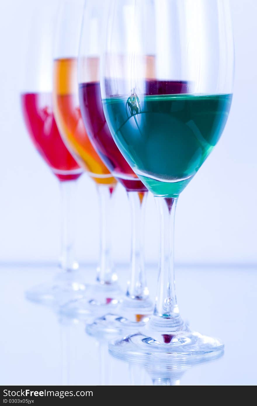 Colored glasses arranged on a glass substrate. Mirror was used as background. Colored glasses arranged on a glass substrate. Mirror was used as background