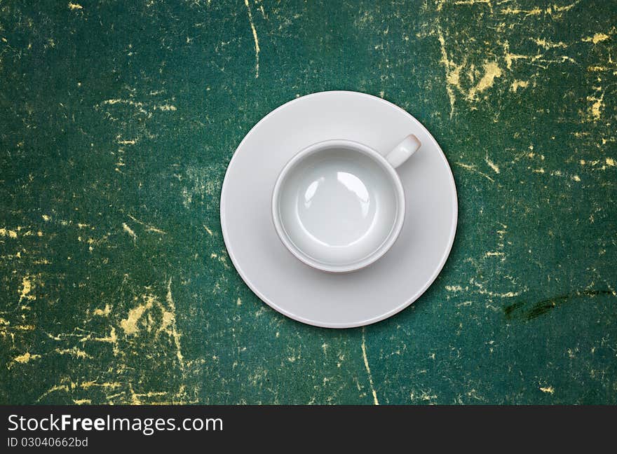 Empty coffee cup on a dirty green table