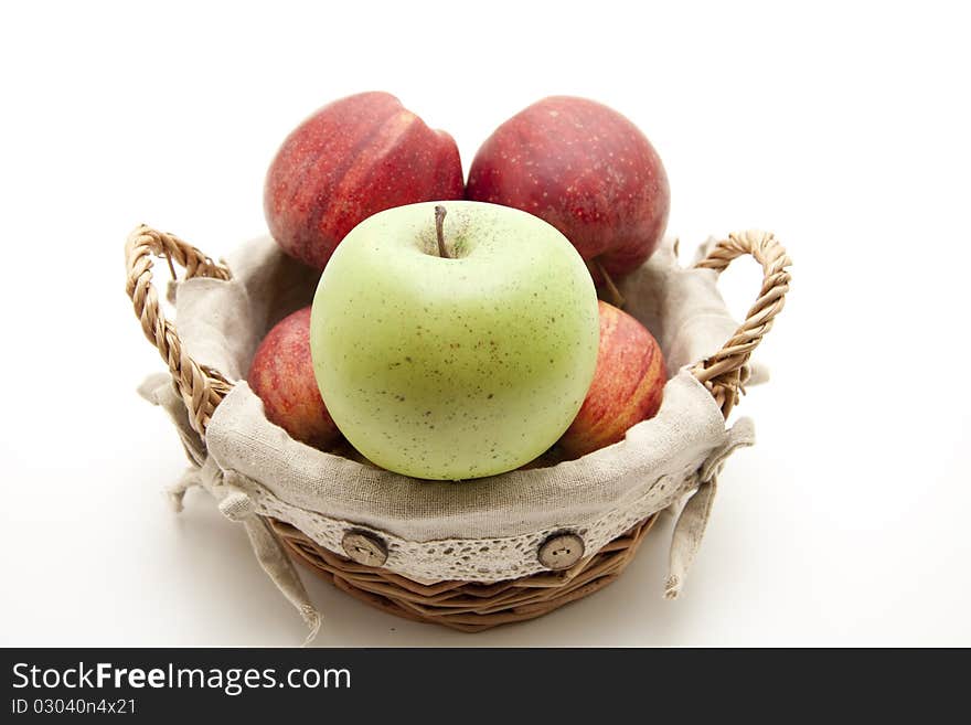 Red apples and green apple in the basket with material