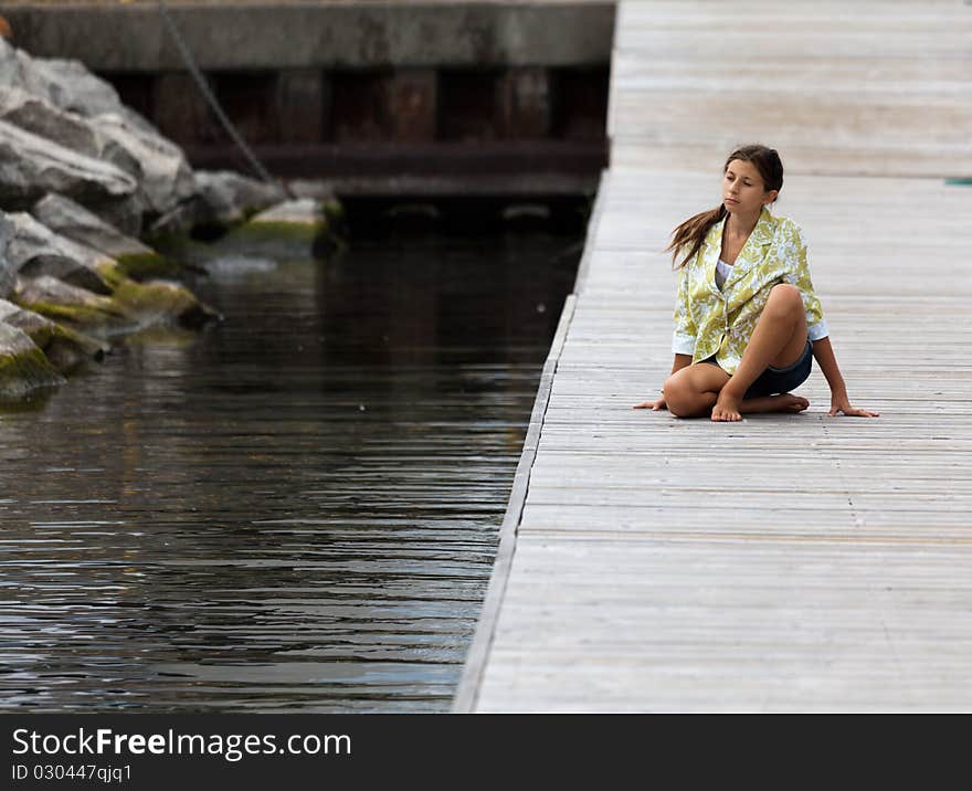 Young Girl In Yoga Posture On A Dock