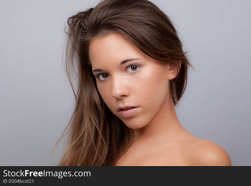 A simple, yet stunning, portrait of a lovely teenager with bare shoulders, staring intensely into the camera. A simple, yet stunning, portrait of a lovely teenager with bare shoulders, staring intensely into the camera.