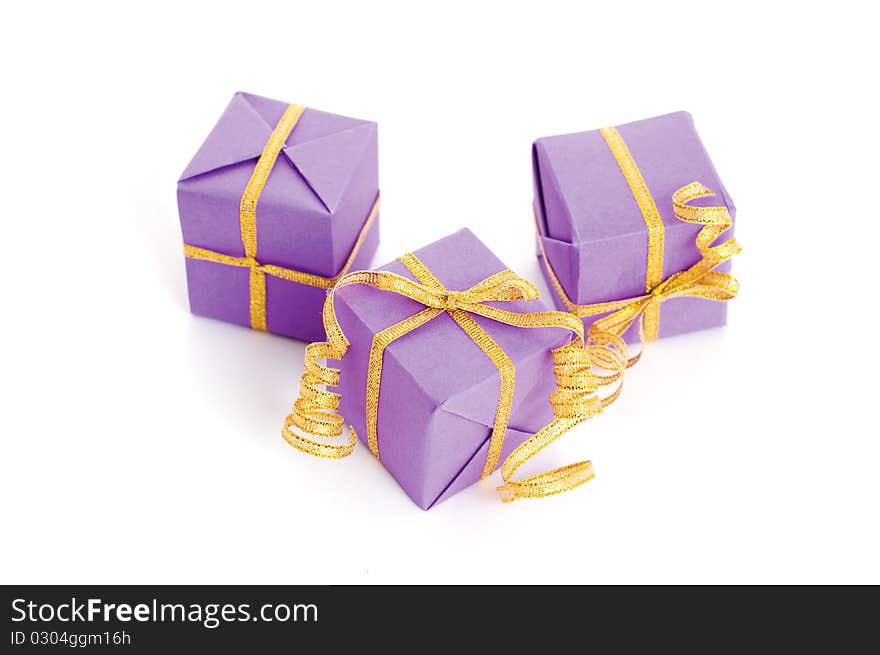 Lilac boxes with golden ribbon isolated on white background. Lilac boxes with golden ribbon isolated on white background