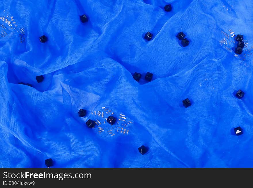 Black beads on blue textile