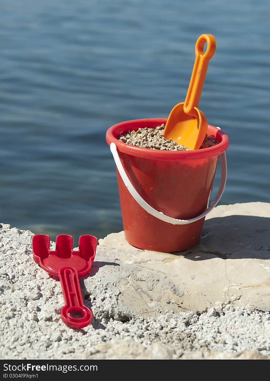 Bucket with sand on the sea coast