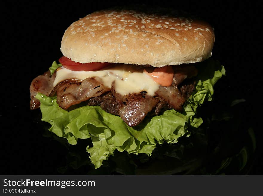 Burger on black slightly reflective plate