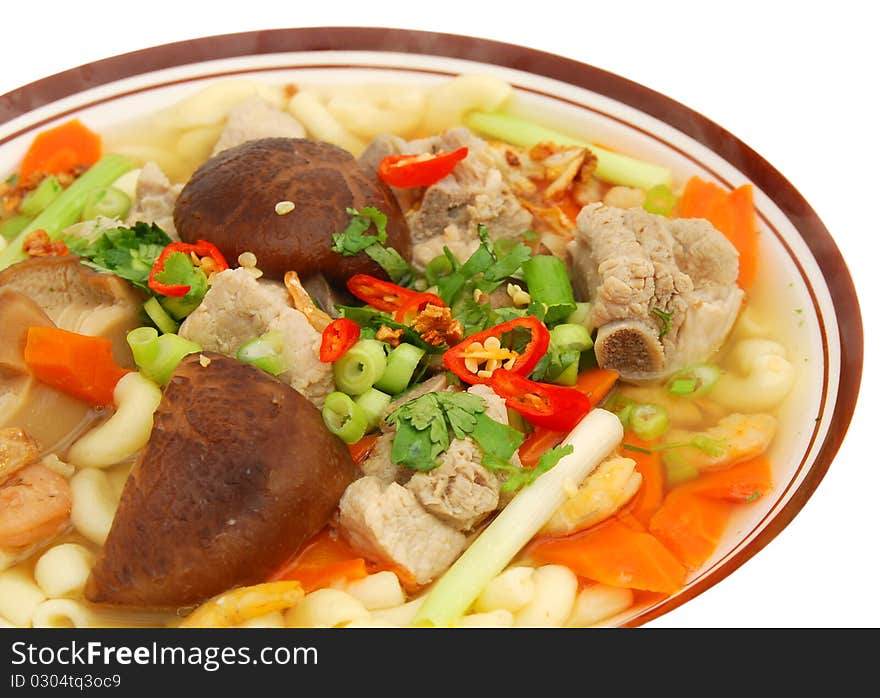 Top view: closeup of a pork pasta noodle soup. Top view: closeup of a pork pasta noodle soup