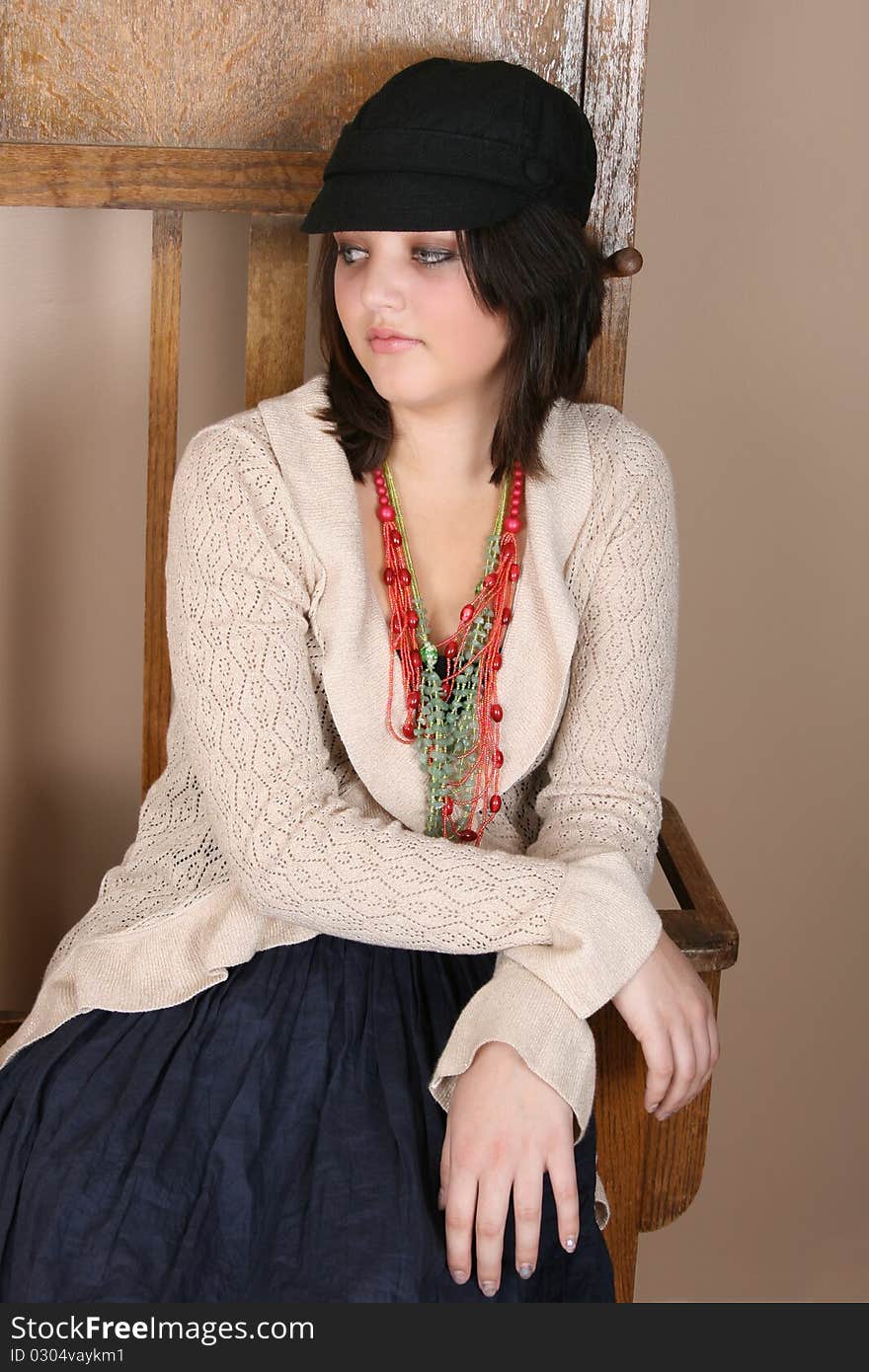 Beautiful teen sitting against an antique coat stand. Beautiful teen sitting against an antique coat stand