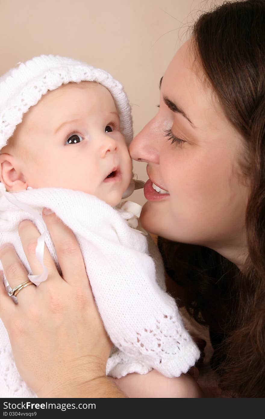 Beautiful brunette mother holding her two month old baby girl. Beautiful brunette mother holding her two month old baby girl