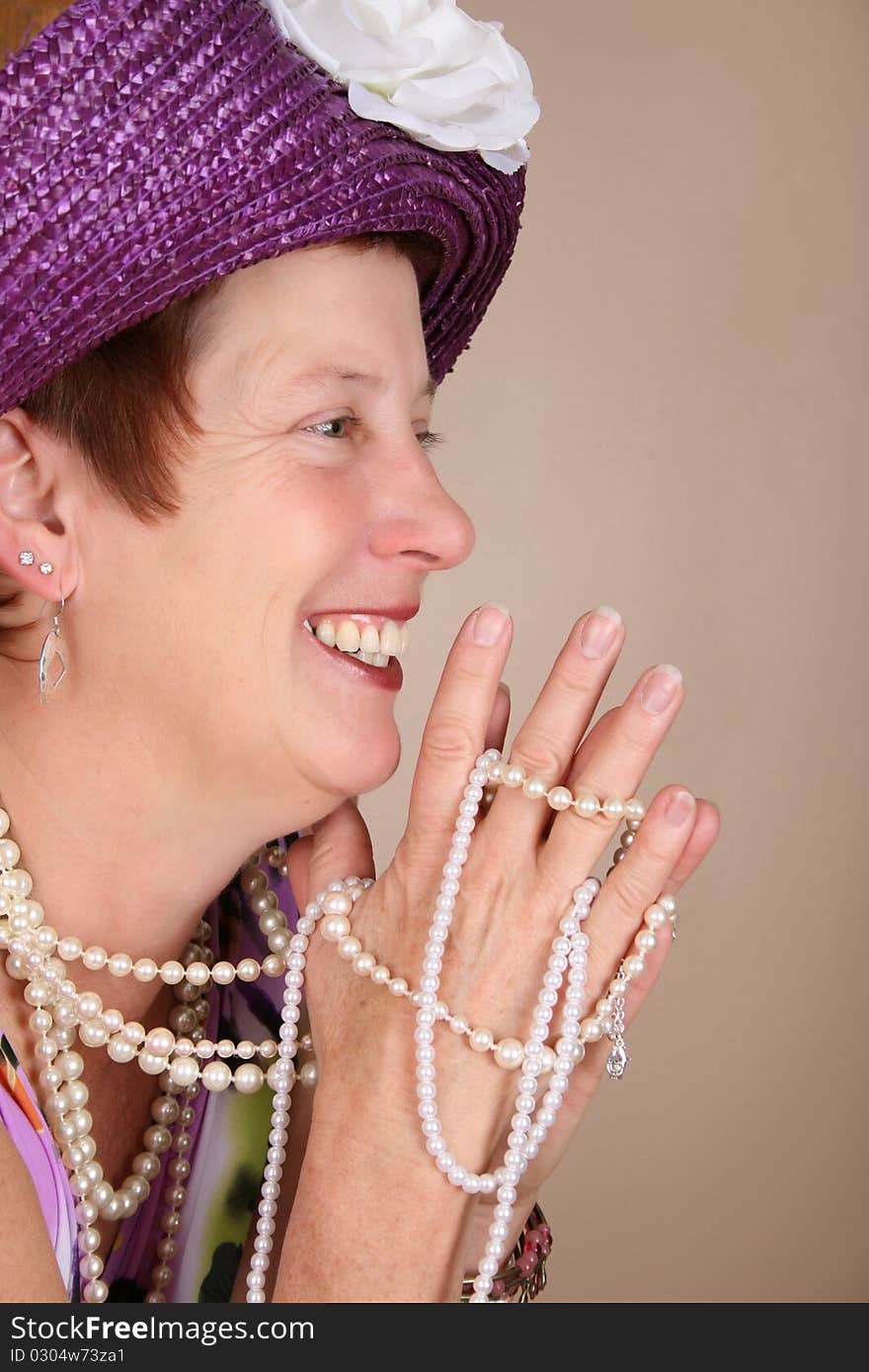 Adult female wearing a purple hat and pearls. Adult female wearing a purple hat and pearls