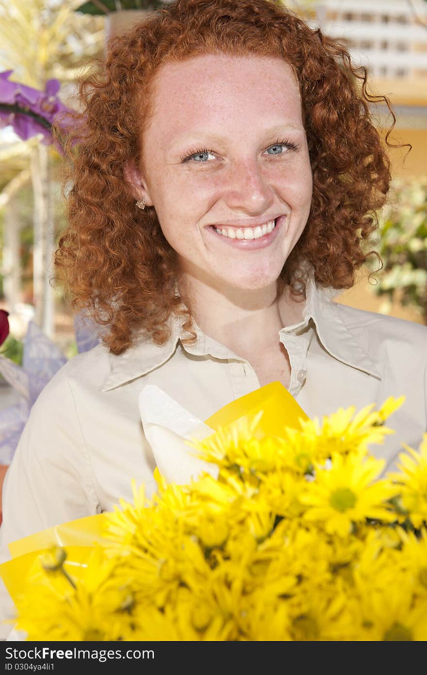 Happy woman holding a bunch of yellow flowers