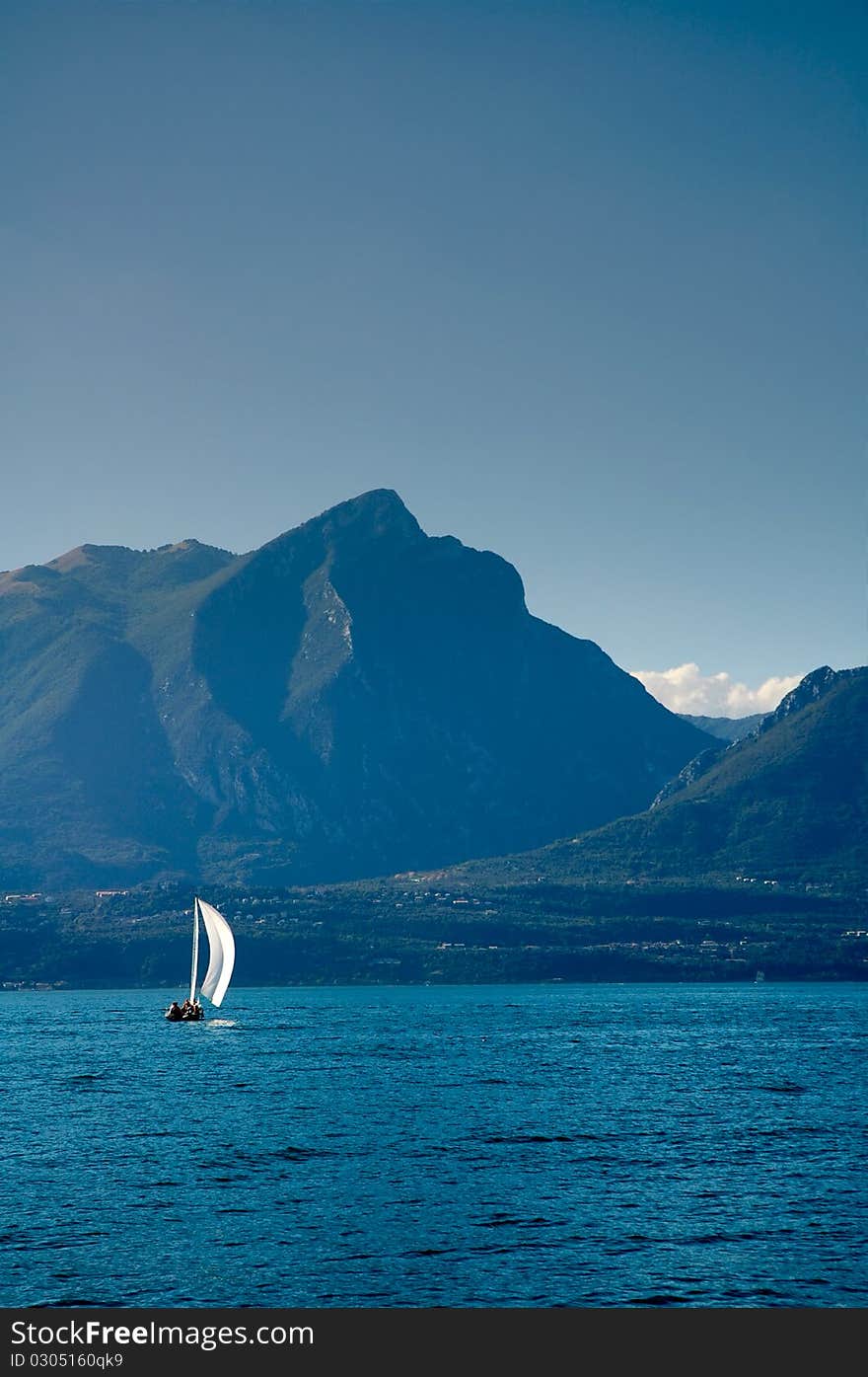 Sailboat at Lake Garda with mountains on the back. Sailboat at Lake Garda with mountains on the back