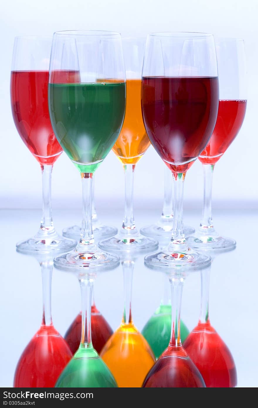 Colored glasses arranged on a glass substrate. Mirror was used as background. Colored glasses arranged on a glass substrate. Mirror was used as background