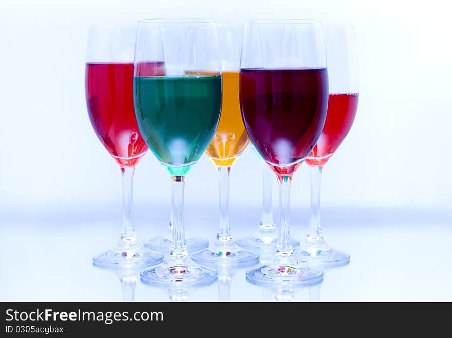 Colored glasses arranged on a glass substrate. Mirror was used as background. Colored glasses arranged on a glass substrate. Mirror was used as background