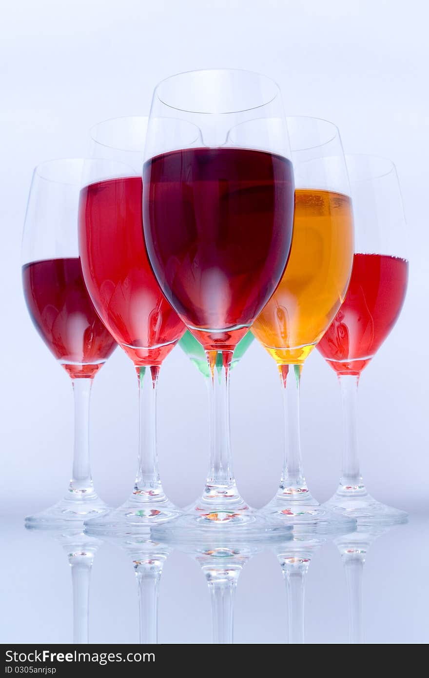 Colored glasses arranged on a glass substrate. Mirror was used as background. Colored glasses arranged on a glass substrate. Mirror was used as background