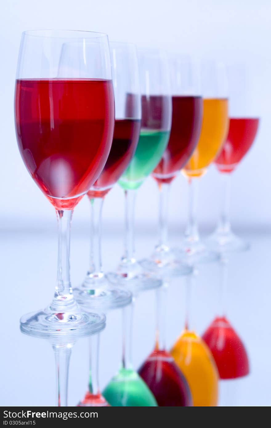 Colored glasses arranged on a glass substrate. Mirror was used as background. Colored glasses arranged on a glass substrate. Mirror was used as background