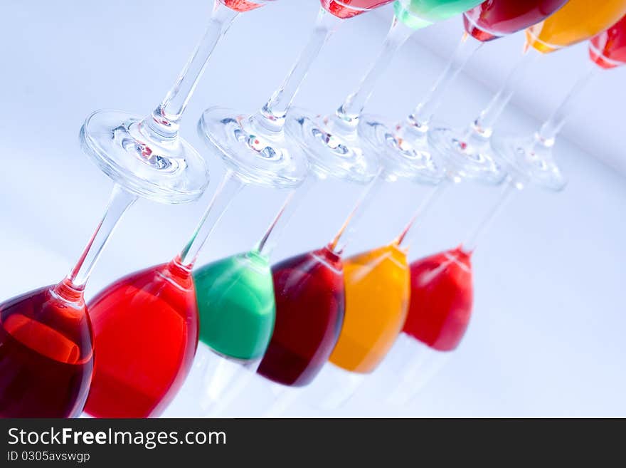 Colored glasses arranged on a glass substrate. Mirror was used as background. Colored glasses arranged on a glass substrate. Mirror was used as background