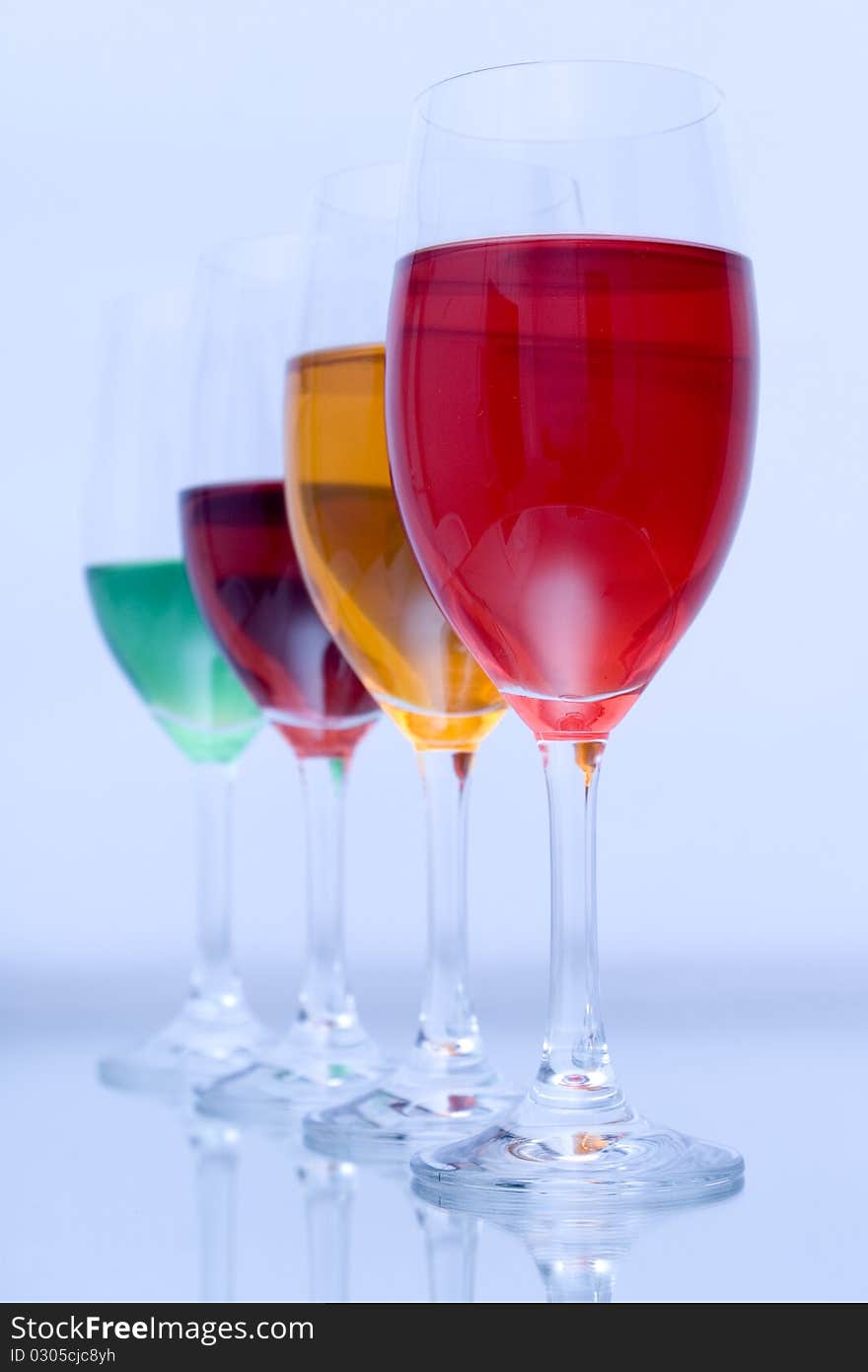 Colored glasses arranged on a glass substrate. Mirror was used as background. Colored glasses arranged on a glass substrate. Mirror was used as background