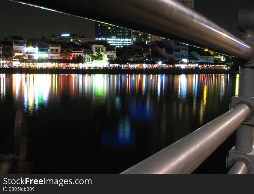 Reflection of modern buildings at Singapore river at night.