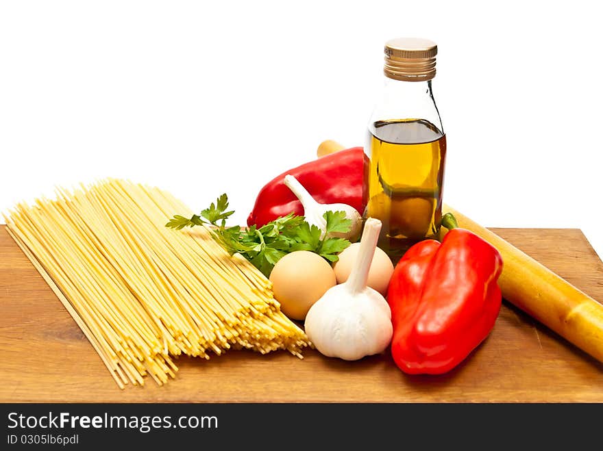 Close-up shot of spaghetti and vegetables on wooden board. Studio shot