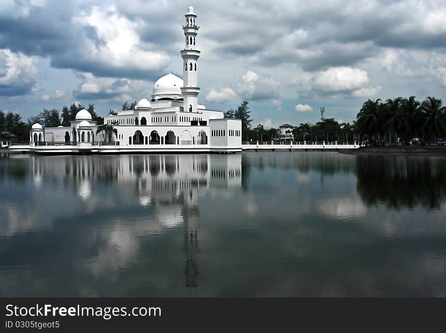 A state mosque built of white marble in Malaysia. Towering minarets with onion-shaped dome amidst landscaped lake. A state mosque built of white marble in Malaysia. Towering minarets with onion-shaped dome amidst landscaped lake.