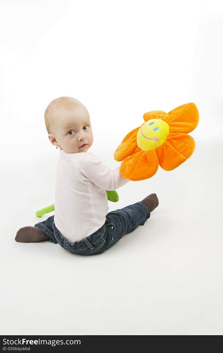 Little girl with flower sit, on white background.