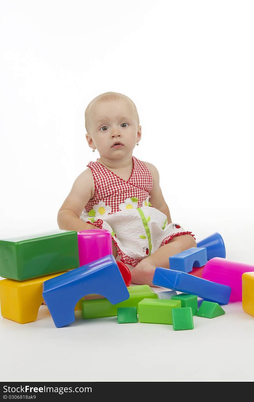 Infant with plastic cubes, on white background.