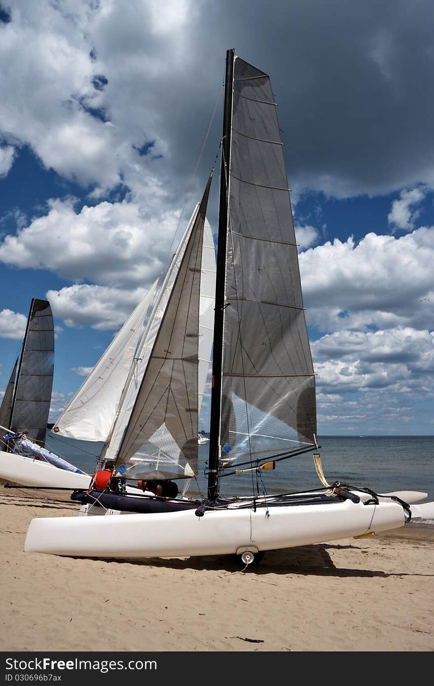 Sail boat ready to ship near a lake with cloudy sky