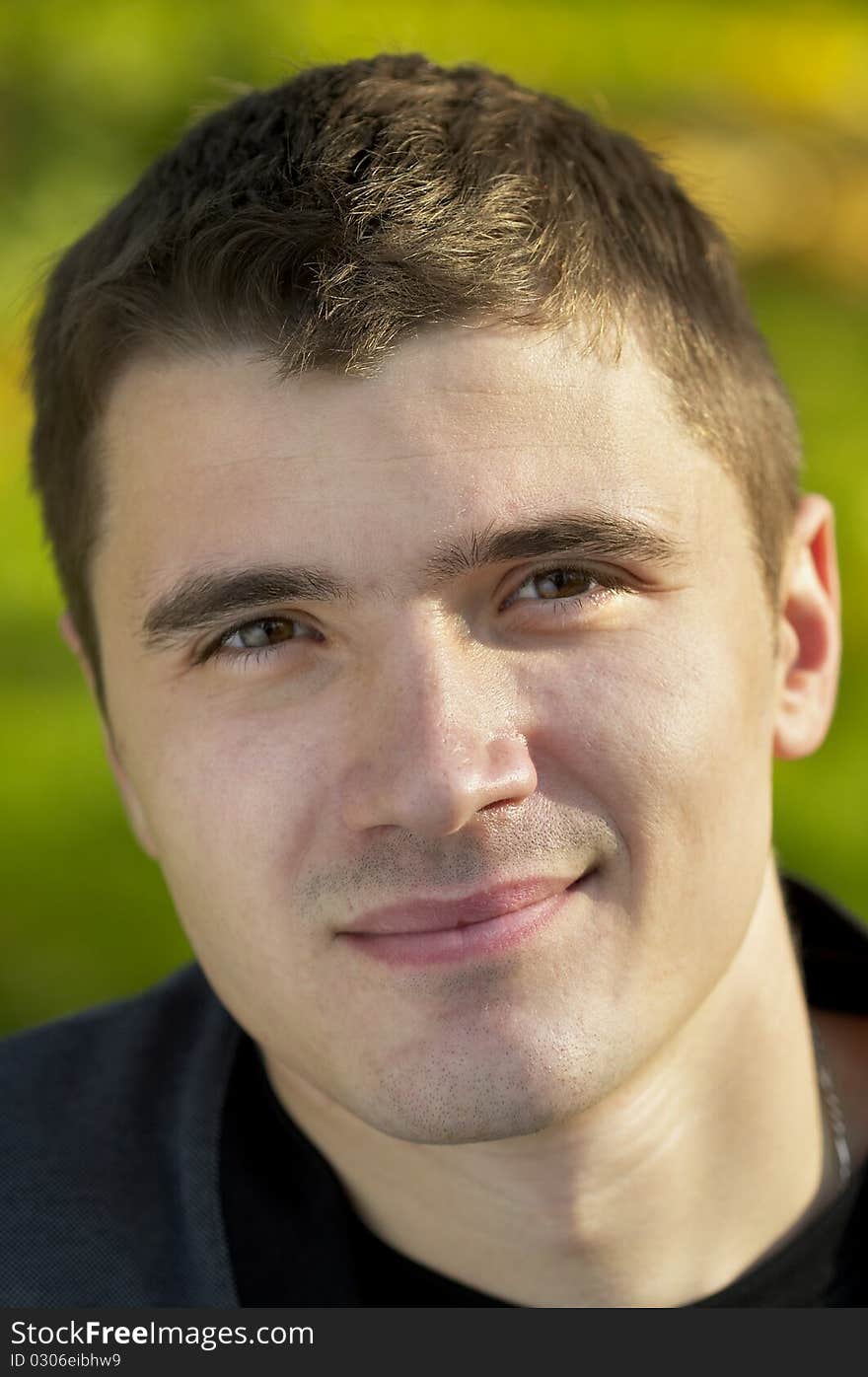 Young man portrait over light autumn defocused background