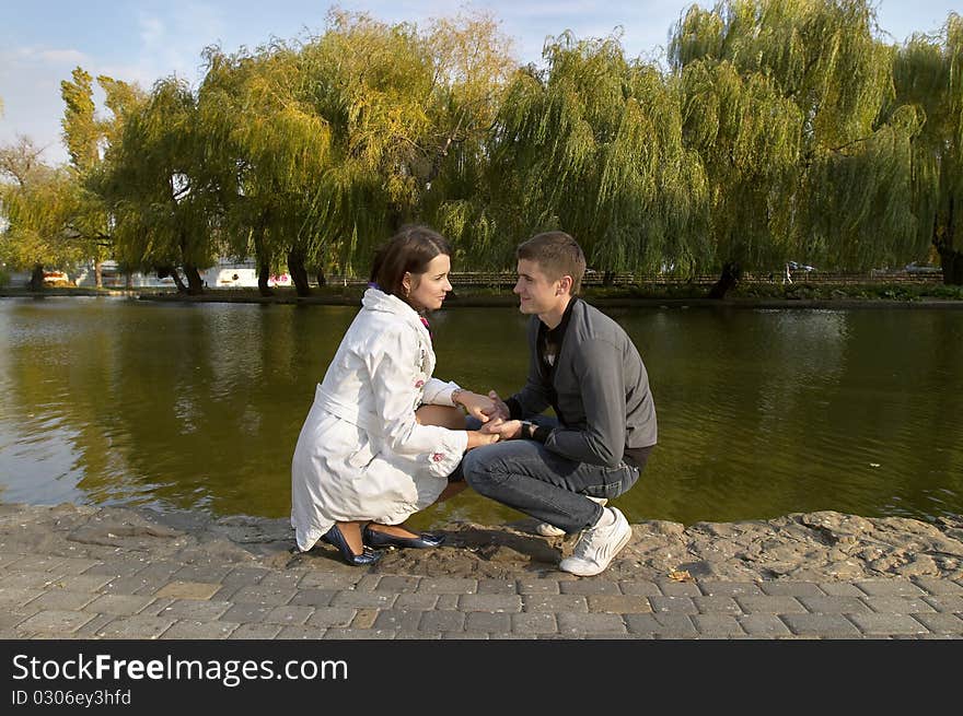 Young couple sitting in the autumn city park (defocused background). Young couple sitting in the autumn city park (defocused background)