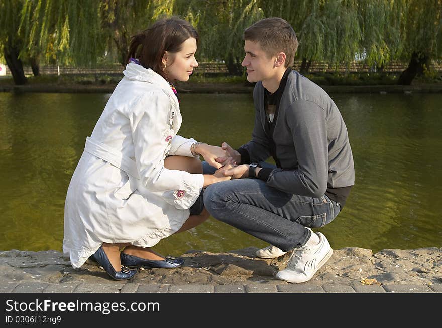 Young couple sitting in the autumn city park (defocused background). Young couple sitting in the autumn city park (defocused background)