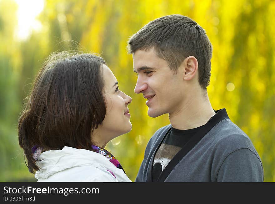 Young couple looking at each other eyes over defocused background. Young couple looking at each other eyes over defocused background