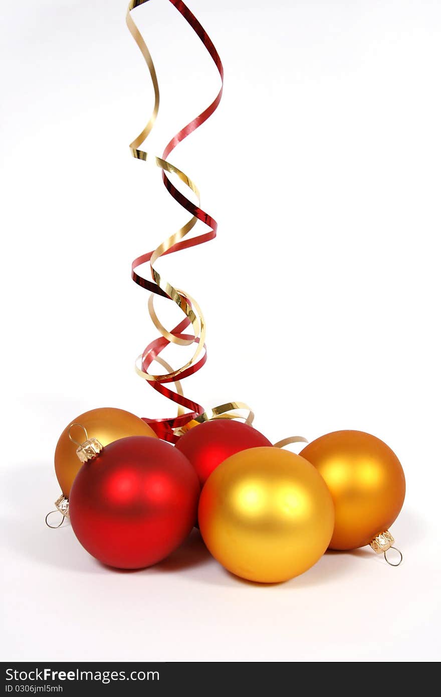 Yellow and red glass balls with ribbons on the white background. Yellow and red glass balls with ribbons on the white background