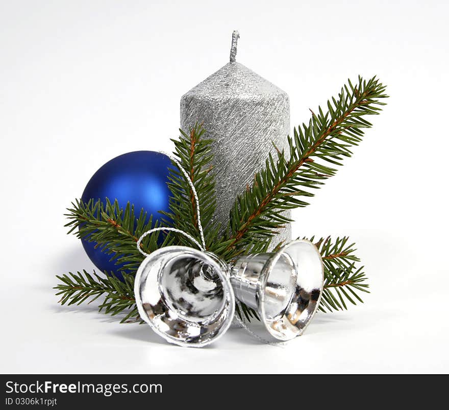 Silver candle with the twig of the spruce and bells