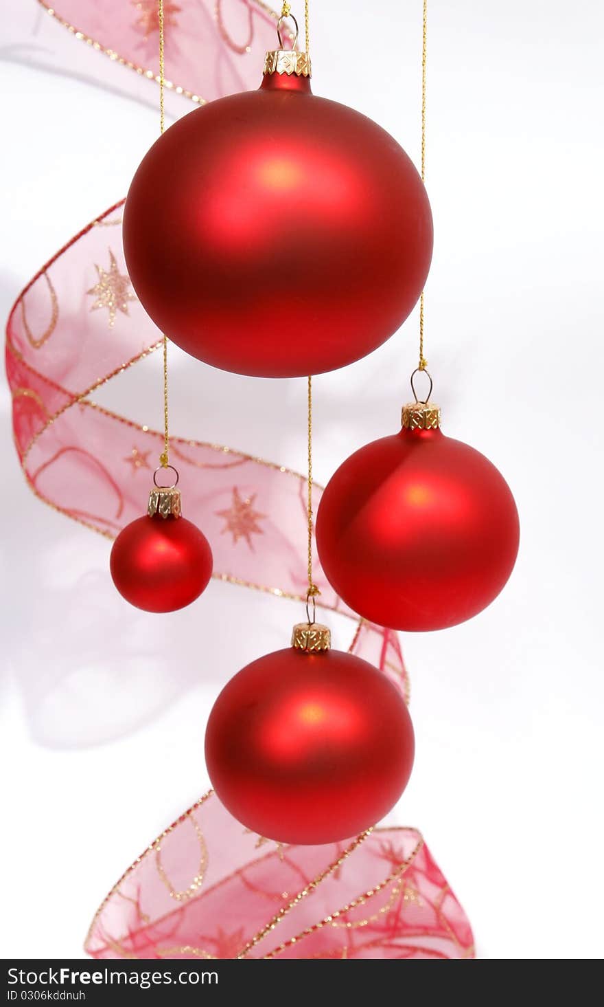 Hanging red glass balls with the ribbon on the white background. Hanging red glass balls with the ribbon on the white background