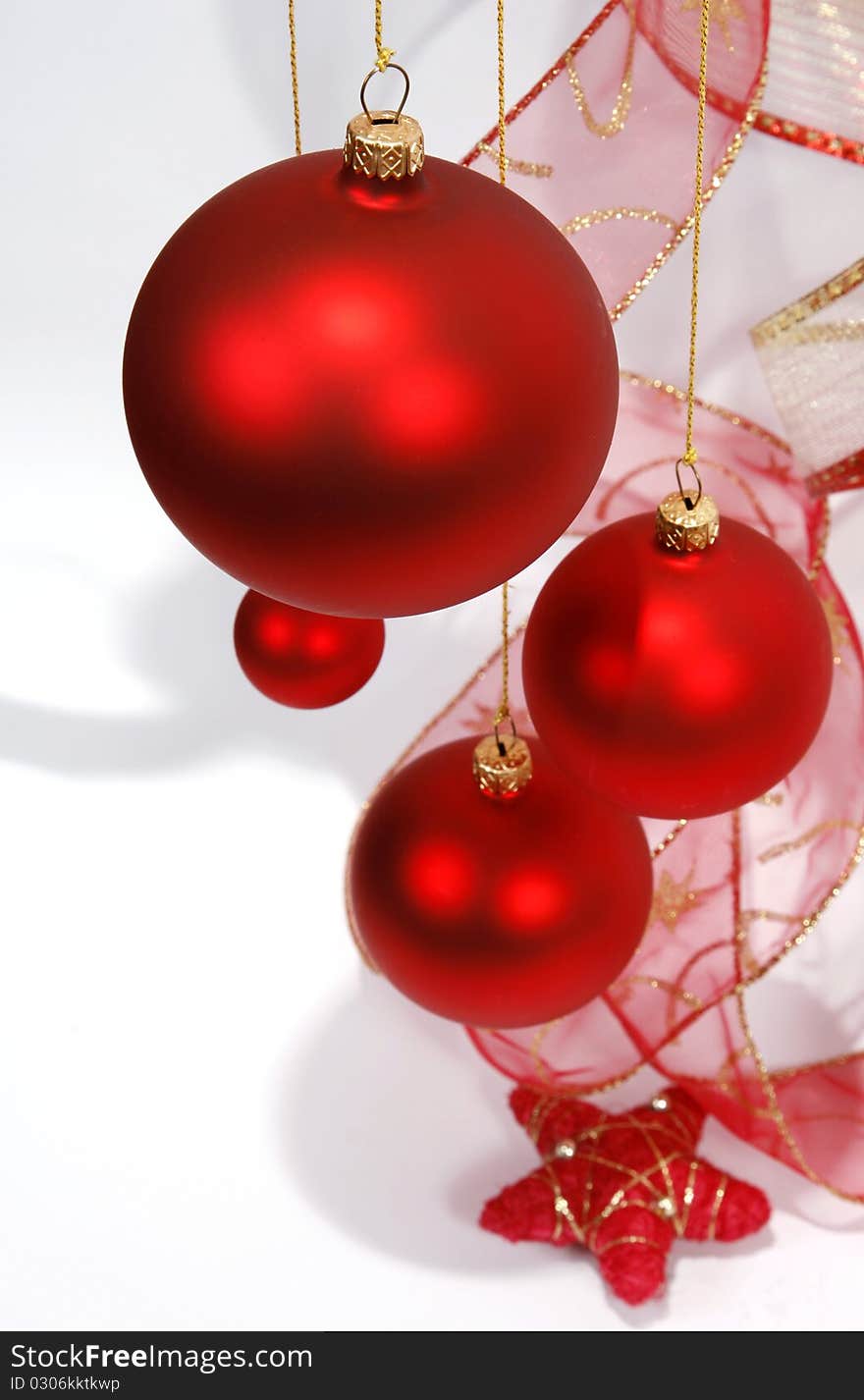 Hanging red glass balls with the ribbon on the white background. Hanging red glass balls with the ribbon on the white background