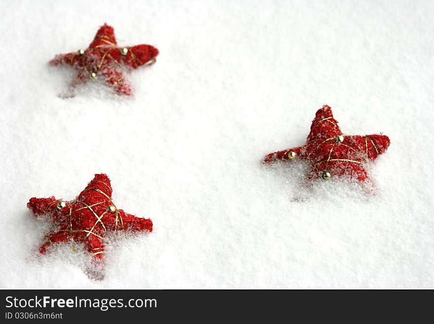 Red christmas stars on the snow