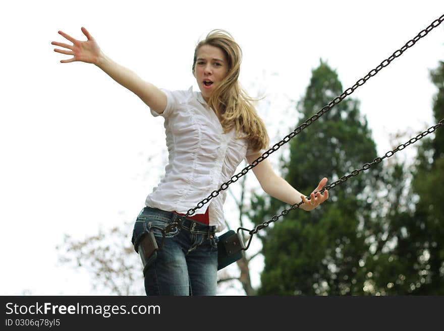 Happy girl on swing with arm extended toward the sky. Happy girl on swing with arm extended toward the sky