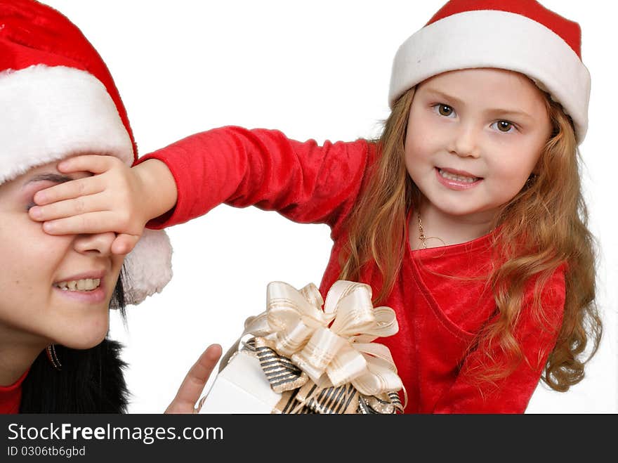 Little girl gives a holiday gift in red box with white ribbon.