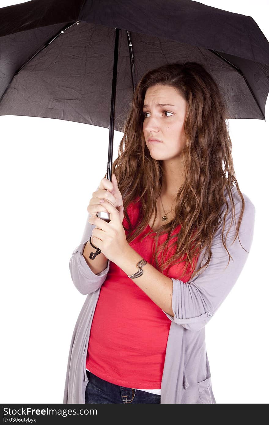 A woman under an umbrella looks frustrated. A woman under an umbrella looks frustrated.