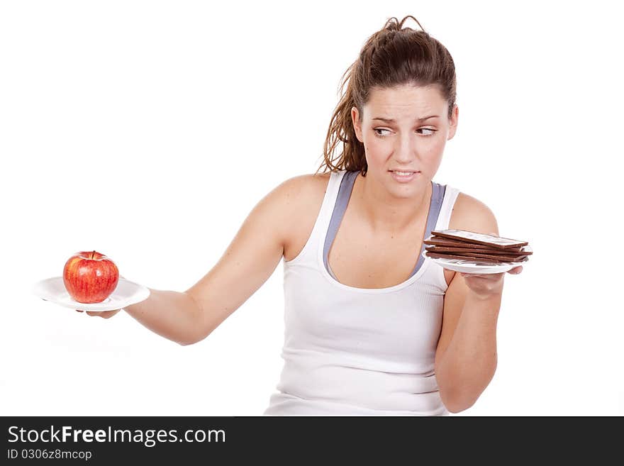 A woman is deciding between chocolate and fruit. A woman is deciding between chocolate and fruit.