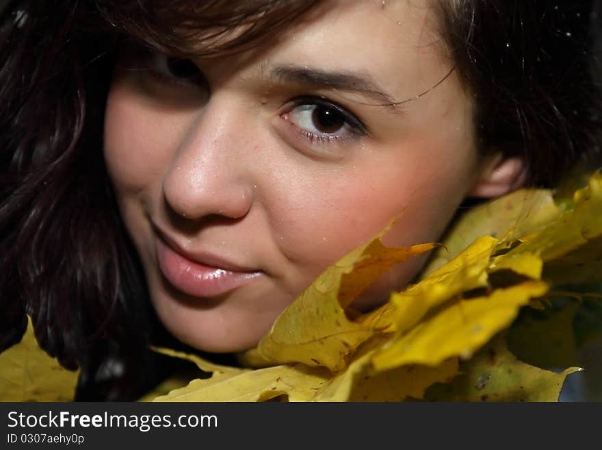 Close-up portrait of woman in red autumn leaves