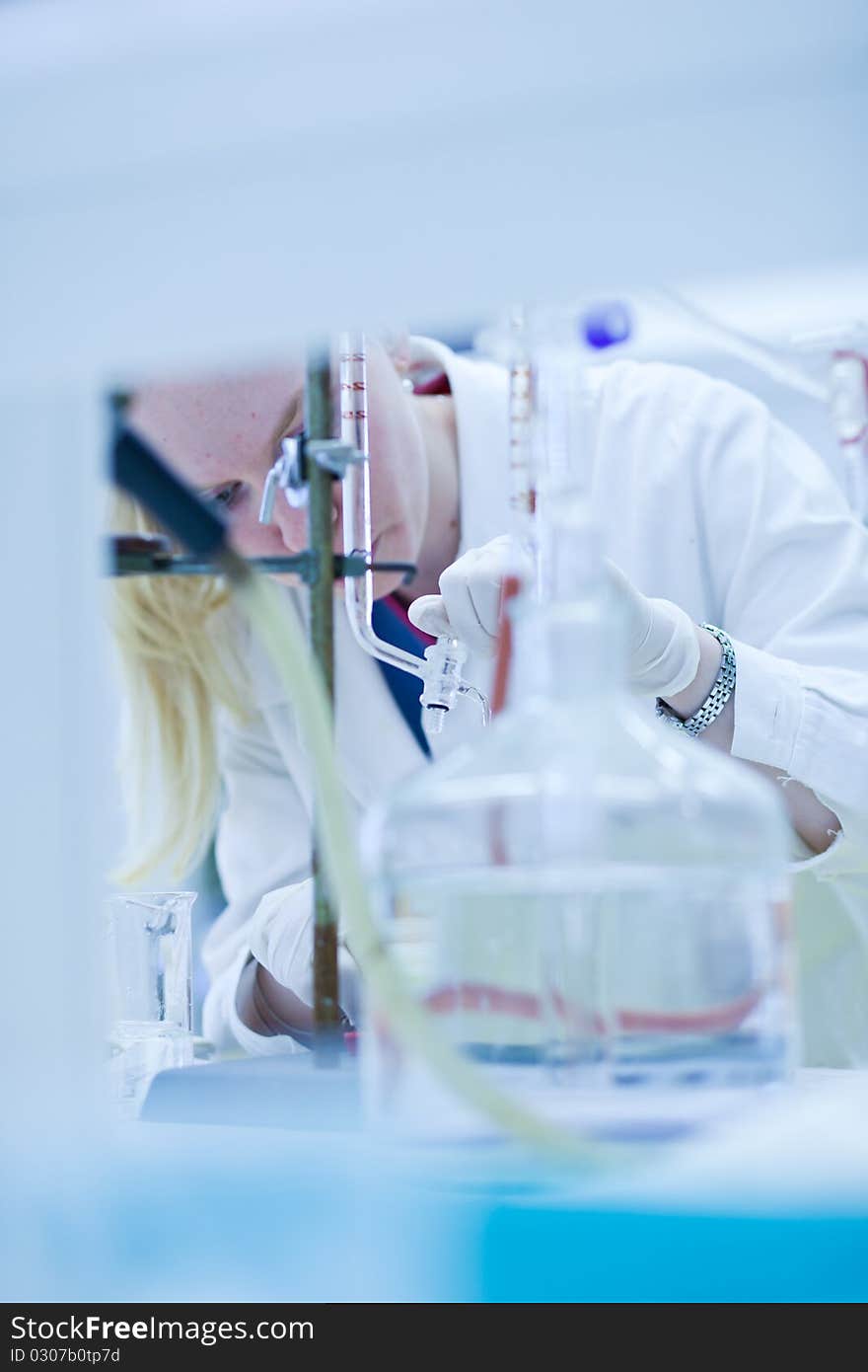 Portrait of a female researcher carrying out research in a chemistry lab (color toned image; shallow DOF)