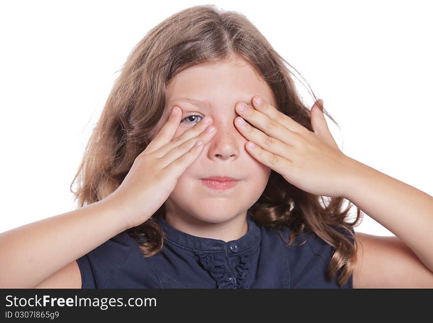 A cute little girls peeks through her fingers while covering her eyes. A cute little girls peeks through her fingers while covering her eyes