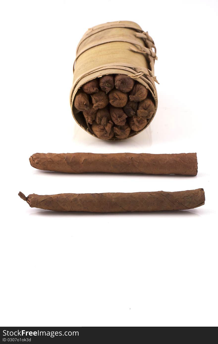 Two hand rolled cigars in front of an authentic cuban humidor, a banana leaf, isolated on a white background