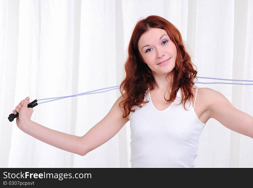 Young girl doing exercises with skipping rope