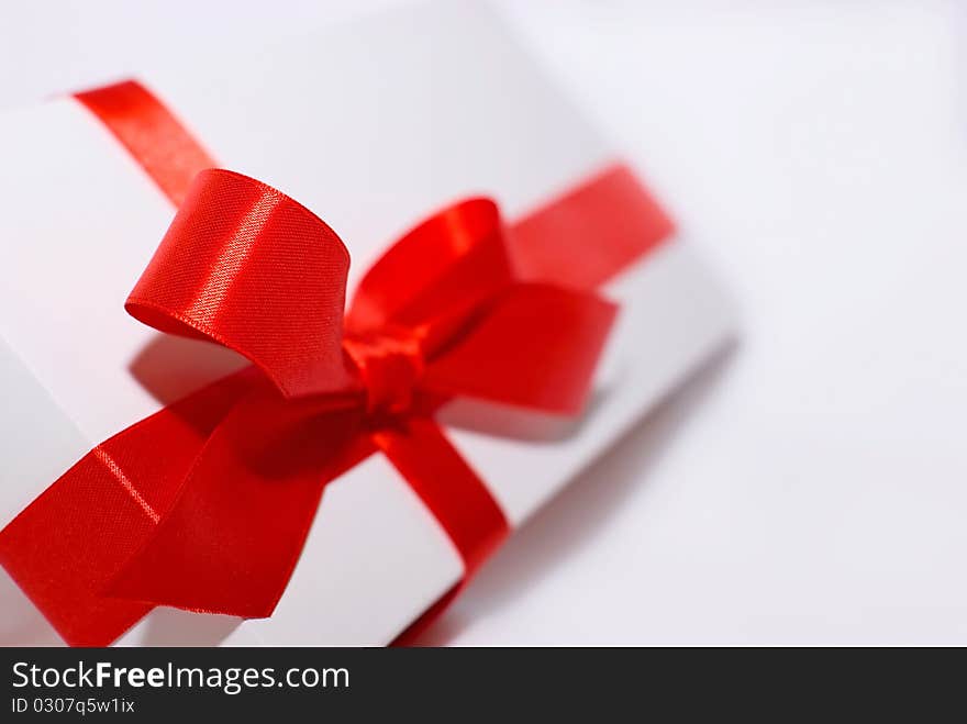 White box with red ribbon on white background. White box with red ribbon on white background