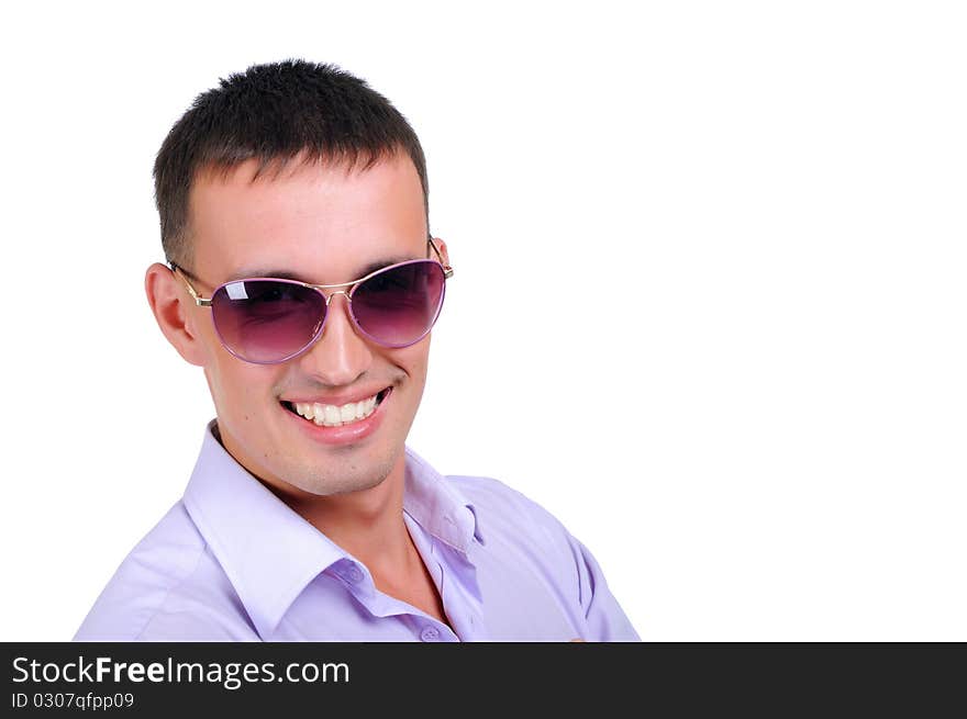 A young man in jeans and a light shirt and dark glasses