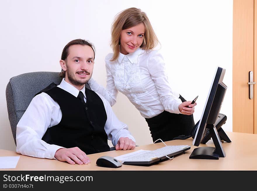 A young business man and a girl running on the computer in the office.