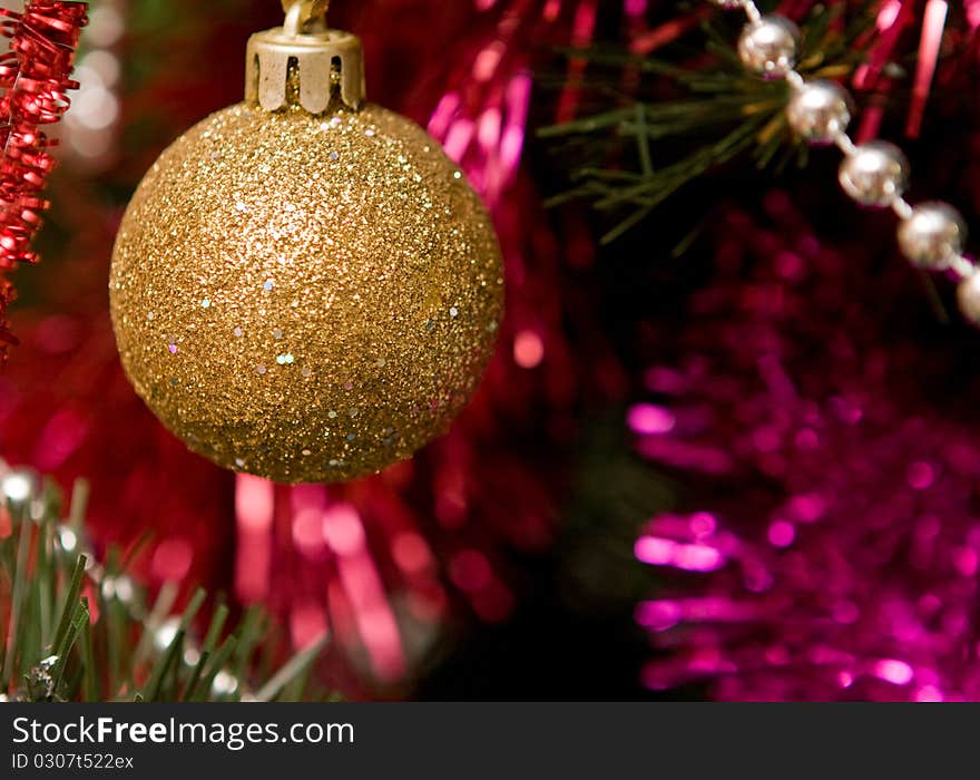 Christmas tree with gold ornament ball, close up